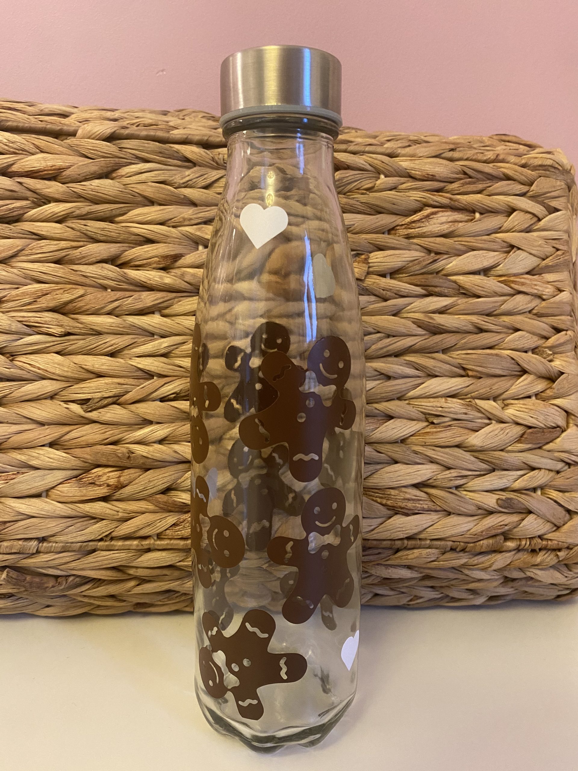 bouteille d'eau en verre avec des bonhommes en pain d'épices marron pour motif